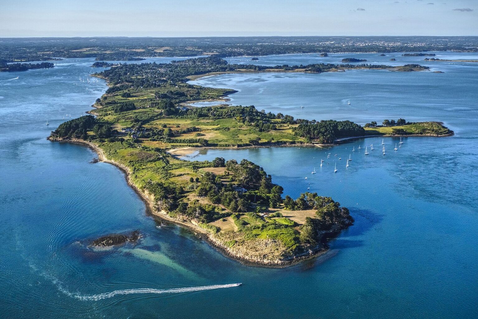 Une île du Golfe du Morbihan entourée de bateaux au mouillage